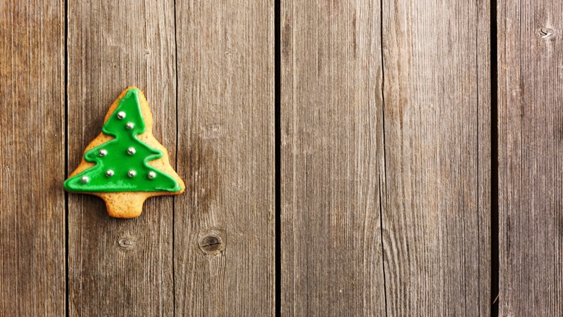 Bildet viser en pepperkake som er formet som et juletre, med grønn melis og sølvperler som pynt.